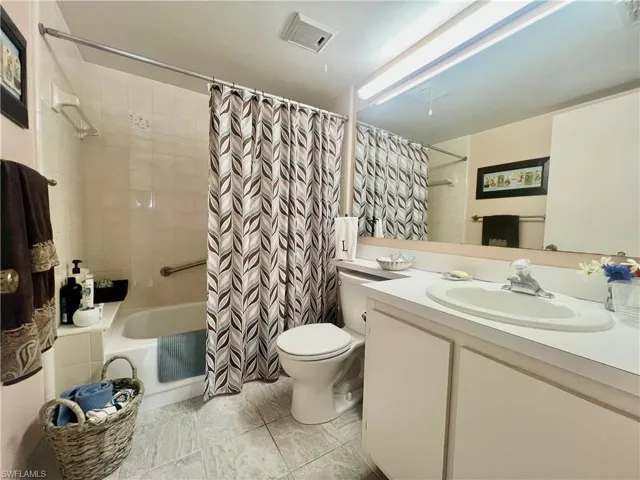 Bathroom featuring vanity and shower / bath combo with shower curtain