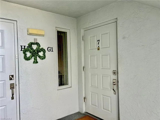 Entrance to property with stucco siding