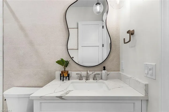 Bathroom with vanity and a textured wall