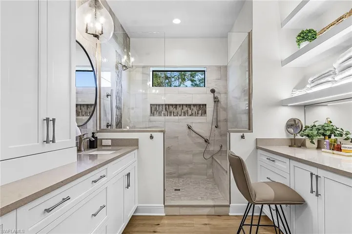 Bathroom with vanity, walk in shower, light wood-type flooring, and recessed lighting