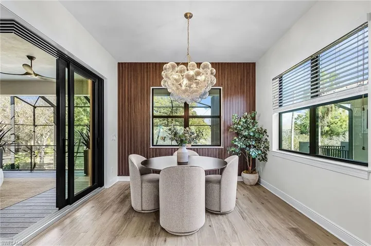 Dining area featuring a chandelier, light wood-type flooring, and a ceiling fan