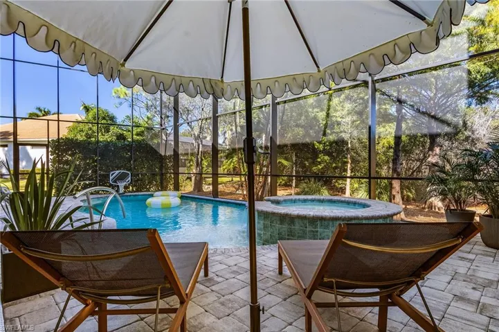 View of swimming pool with a lanai, a pool with connected hot tub, and a patio area
