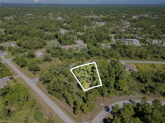 Aerial view of property's location featuring property parcel outlined and a forest