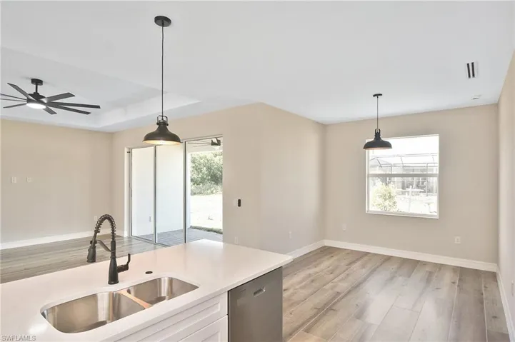 Kitchen island with dual stainless steel sink, pull-down faucet, and white countertop