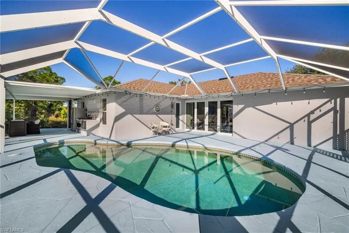 View of swimming pool featuring a patio and glass enclosure