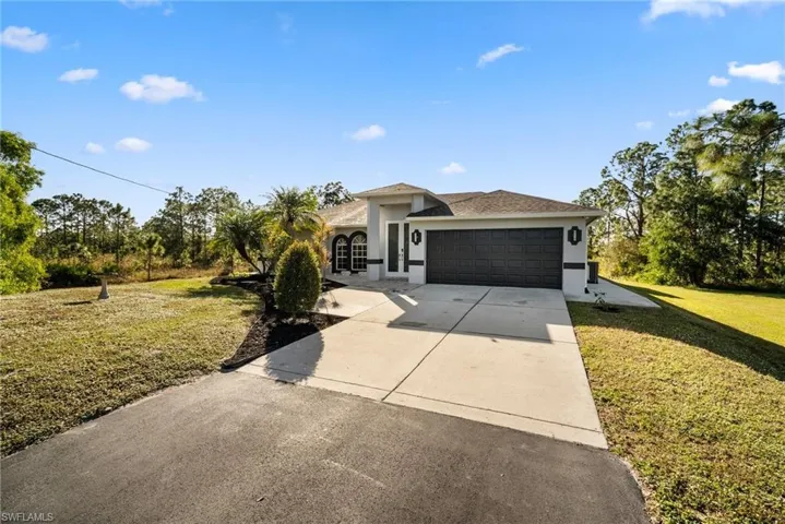 View of front of house with a front lawn and a garage