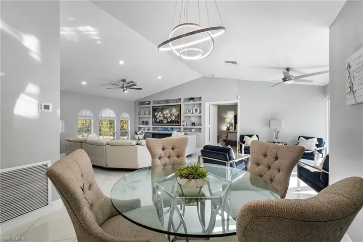 Tiled dining space featuring built in shelves, vaulted ceiling, and ceiling fan