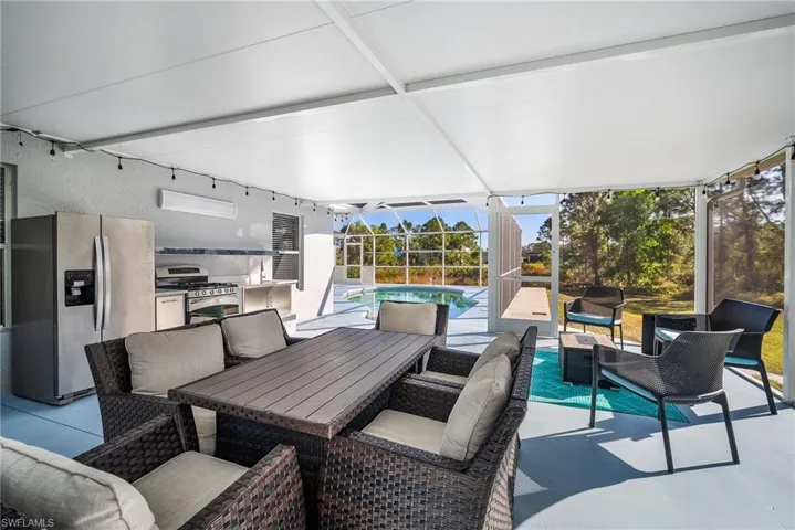 View of patio with a lanai, outdoor lounge area, and exterior kitchen