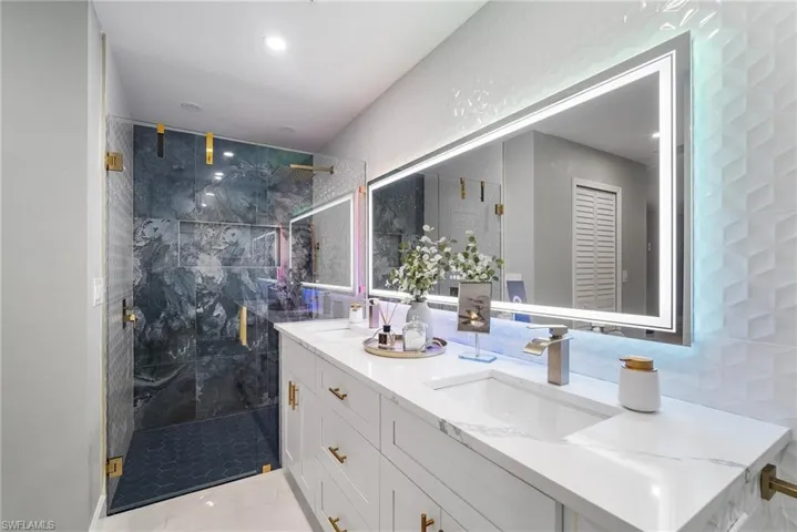 Bathroom with vanity, tiled shower, and tile walls