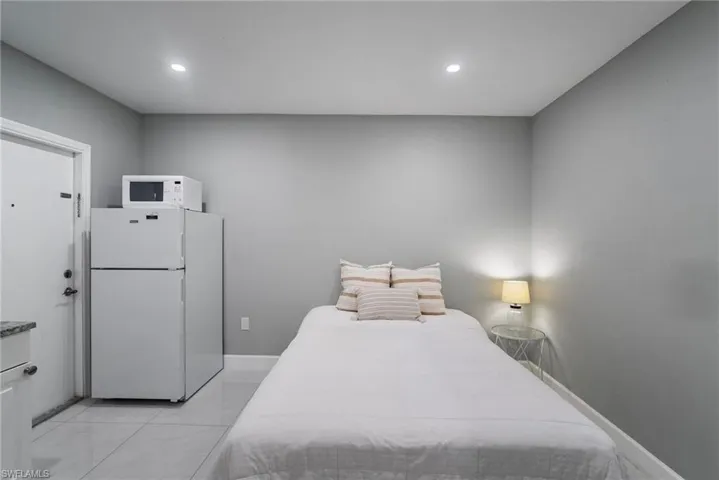 Bedroom featuring white refrigerator