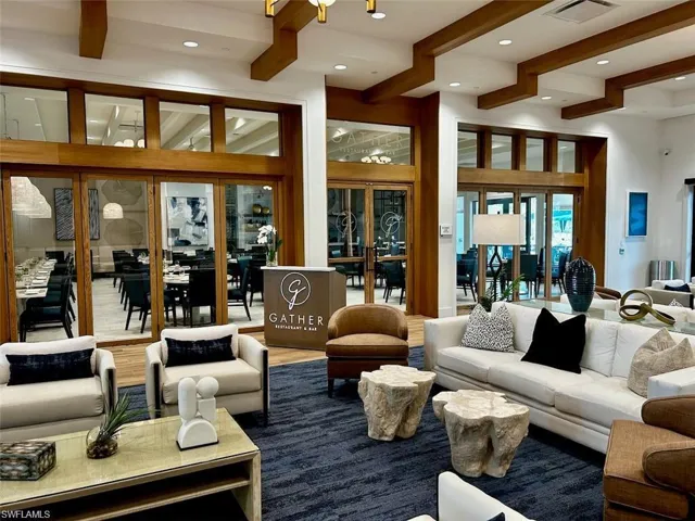 Spacious lounge area featuring a textured blue carpet, white sofa, and unique stone-finish side tables