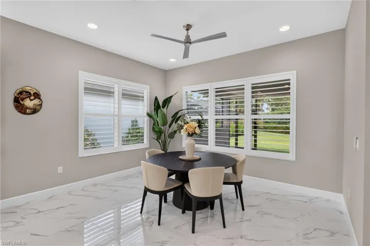 Bright interior space featuring large windows with white louvered shutters