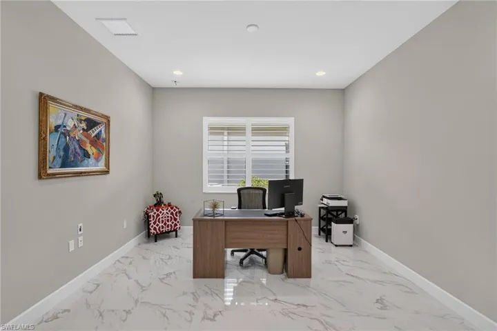 Bright interior room featuring a large window with white blinds, recessed lighting, and light-toned walls