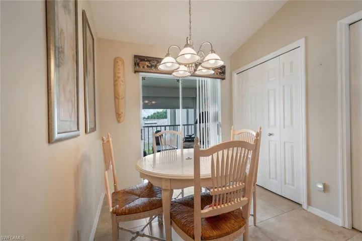 Dining space with a notable chandelier, vaulted ceiling, and light tile flooring