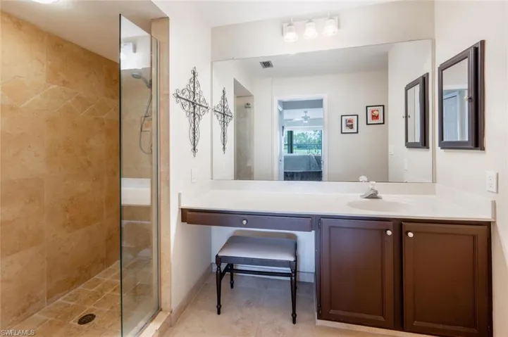 Bathroom featuring walk in shower, tile flooring, and oversized vanity
