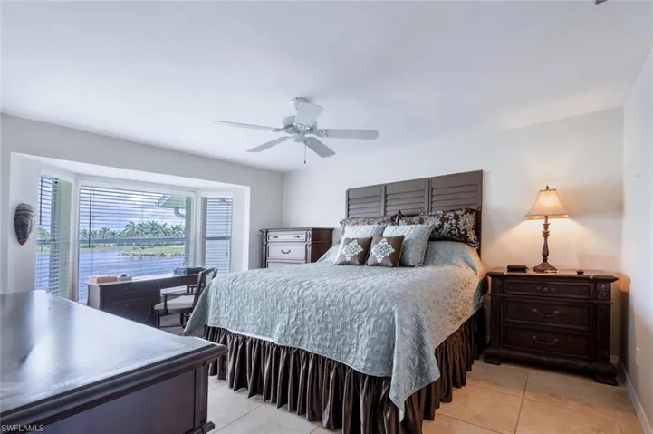 Tiled bedroom featuring ceiling fan