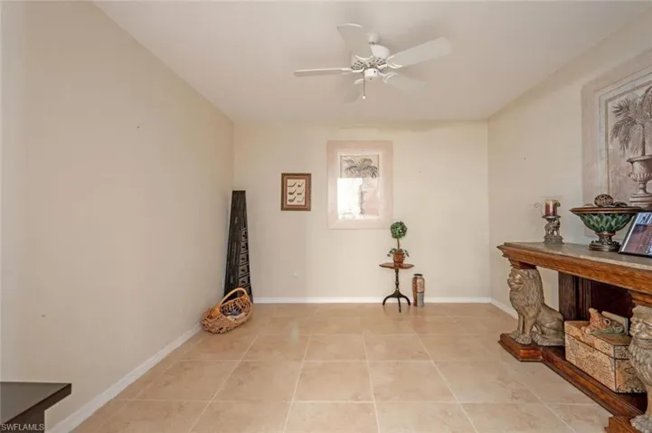 Living area featuring ceiling fan and light tile floors