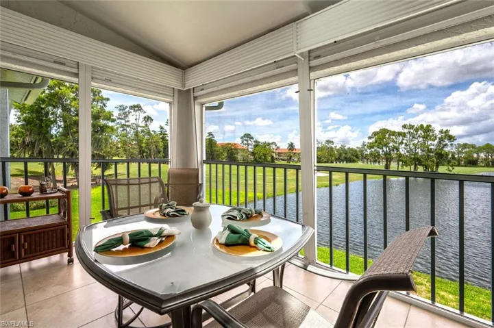 Sunroom featuring a water view and lofted ceiling