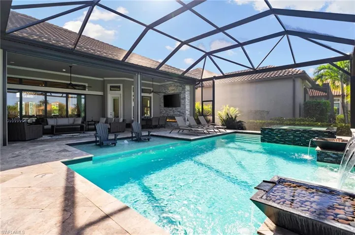 View of pool featuring outdoor lounge area, a pool with connected hot tub, glass enclosure, a sunroom, and a patio