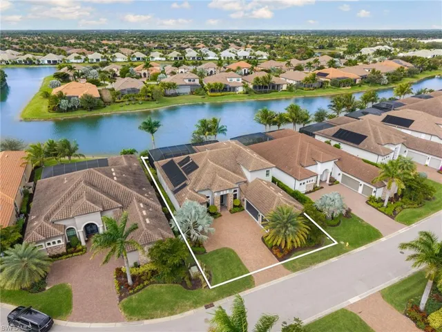 Aerial view of residential area with a nearby body of water and property boundaries highlighted