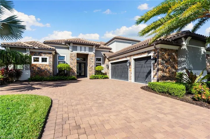 Mediterranean / spanish-style home with an attached garage, decorative driveway, stone siding, french doors, and stucco siding