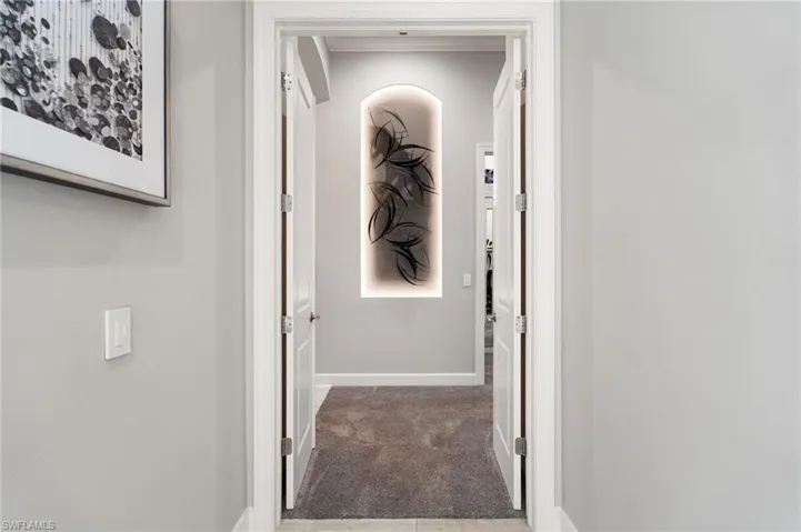 Corridor featuring baseboards and carpet flooring