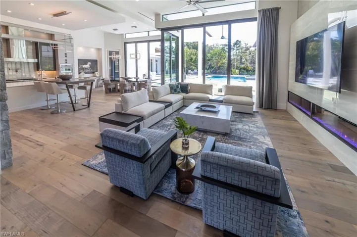 Living room featuring wood floors,  a high ceiling, and a wealth of natural light