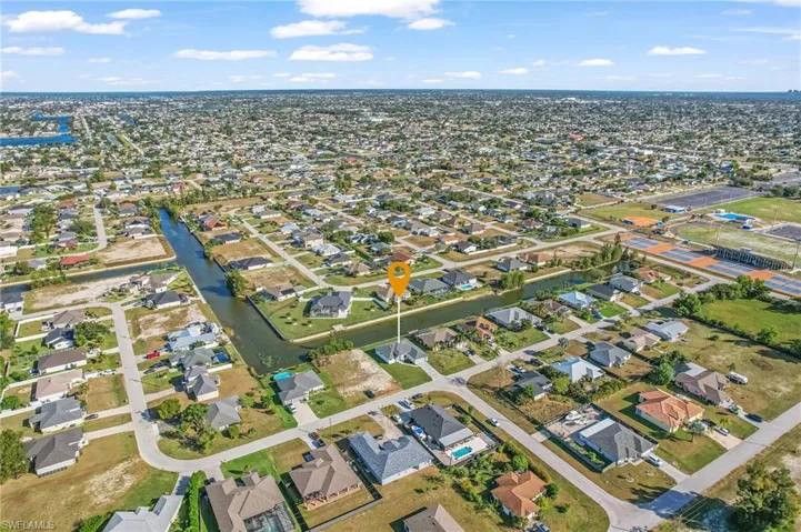 Aerial view of property and surrounding area with nearby suburban area and a large body of water