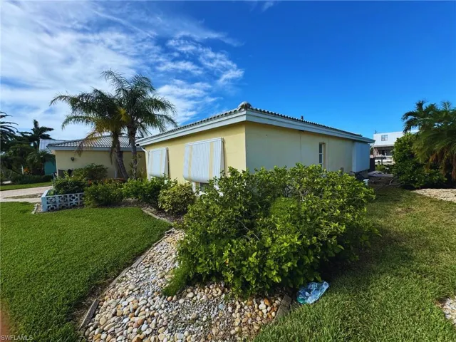 Side profile of the home, surrounded by organized and functional landscaping - Virtually Edited Image