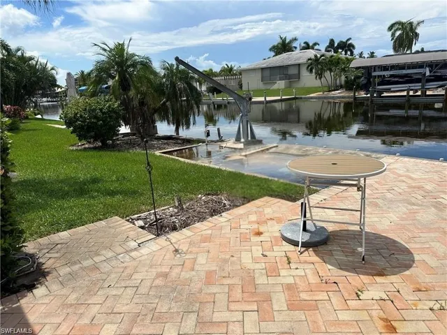 Brick-paved patio overlooking a tranquil canal with private dock access- Virtually Edited Image