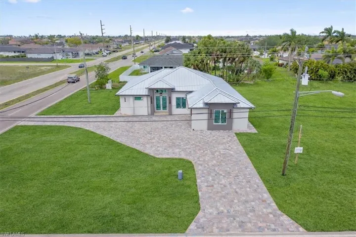 The property features a contemporary architectural style with a light-colored exterior and a prominent metal roof