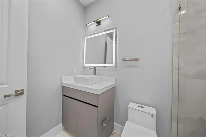Modern vanity with a vessel sink, integrated LED mirror, and quartz countertop