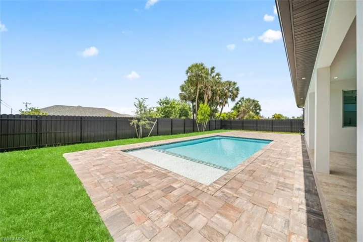 Rectangular swimming pool surrounded by paver decking