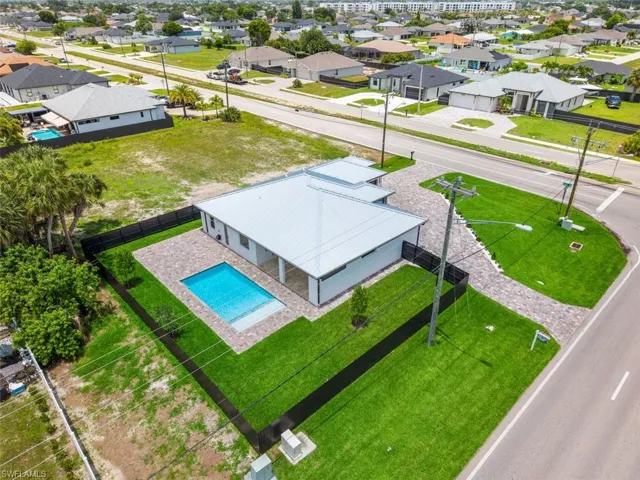 Modern residence featuring a metal roof, white exterior siding, and a private swimming pool