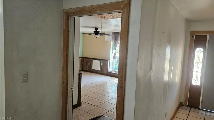 Hallway featuring light tile patterned flooring and baseboards