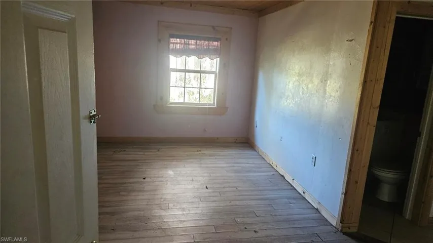 Empty room featuring baseboards and hardwood / wood-style floors