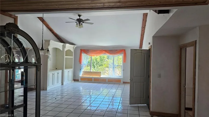 Unfurnished living room featuring ceiling fan and light tile patterned flooring