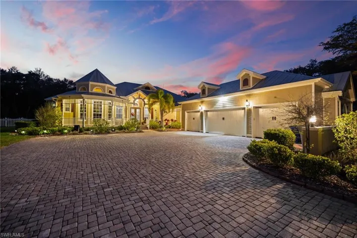 View of front facade featuring decorative driveway, a metal roof, and a garage