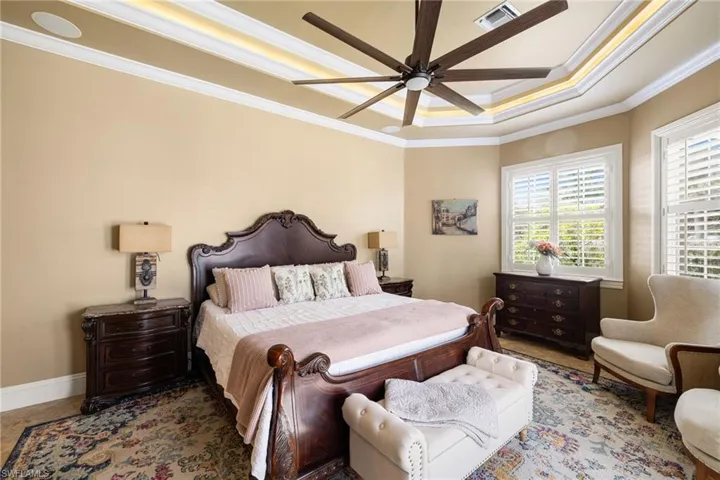 Bedroom featuring crown molding, a ceiling fan, and a tray ceiling