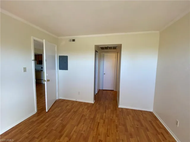 Room featuring wood-finish flooring, neutral wall paint, and white trim