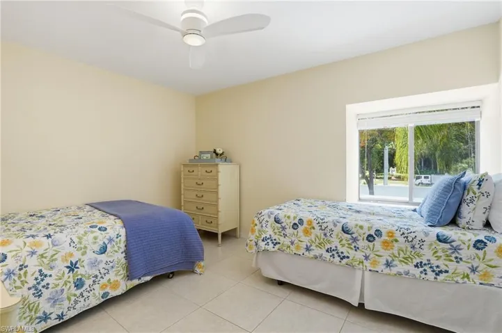 Bright room featuring a window with white blinds, neutral wall tones, and tiled flooring