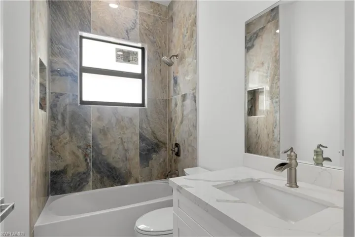 Full bath featuring  shower combination, vanity, and toilet