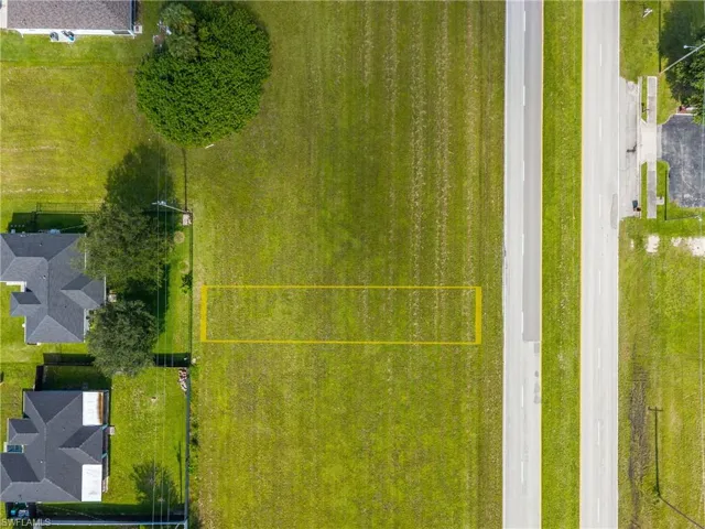 Aerial view of property and surrounding area with property parcel outlined