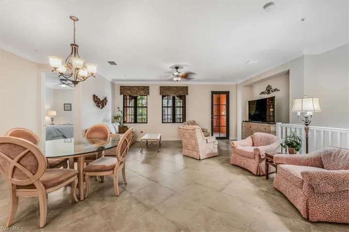 Dining area featuring a ceiling fan, a chandelier, crown molding, and light tile patterned floors