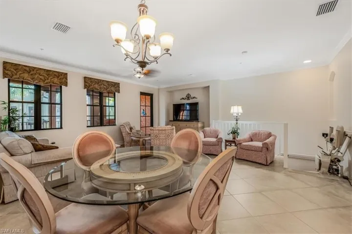 Dining area featuring crown molding, a chandelier, and light tile patterned floors
