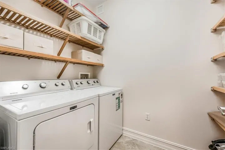 Laundry room featuring separate washer and dryer and light tile patterned floors