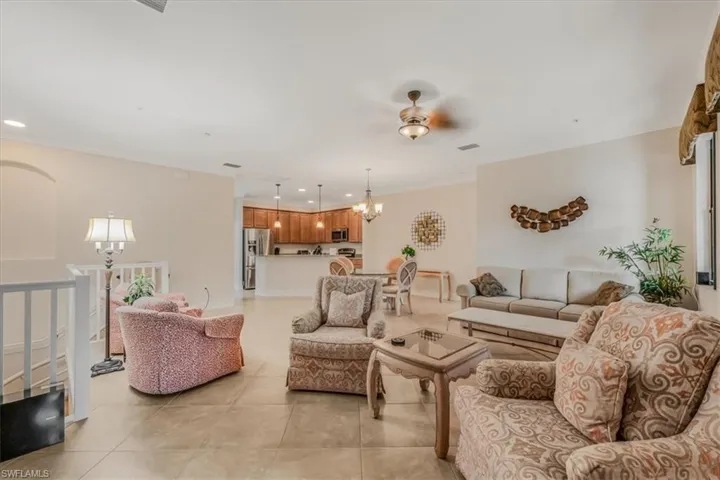 Living room with a chandelier, light tile patterned flooring, and recessed lighting