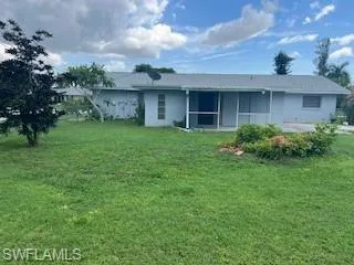Back of property with a yard