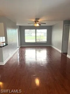 Unfurnished living room featuring wood finished floors and ceiling fan