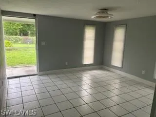 Empty room with light tile patterned floors and plenty of natural light